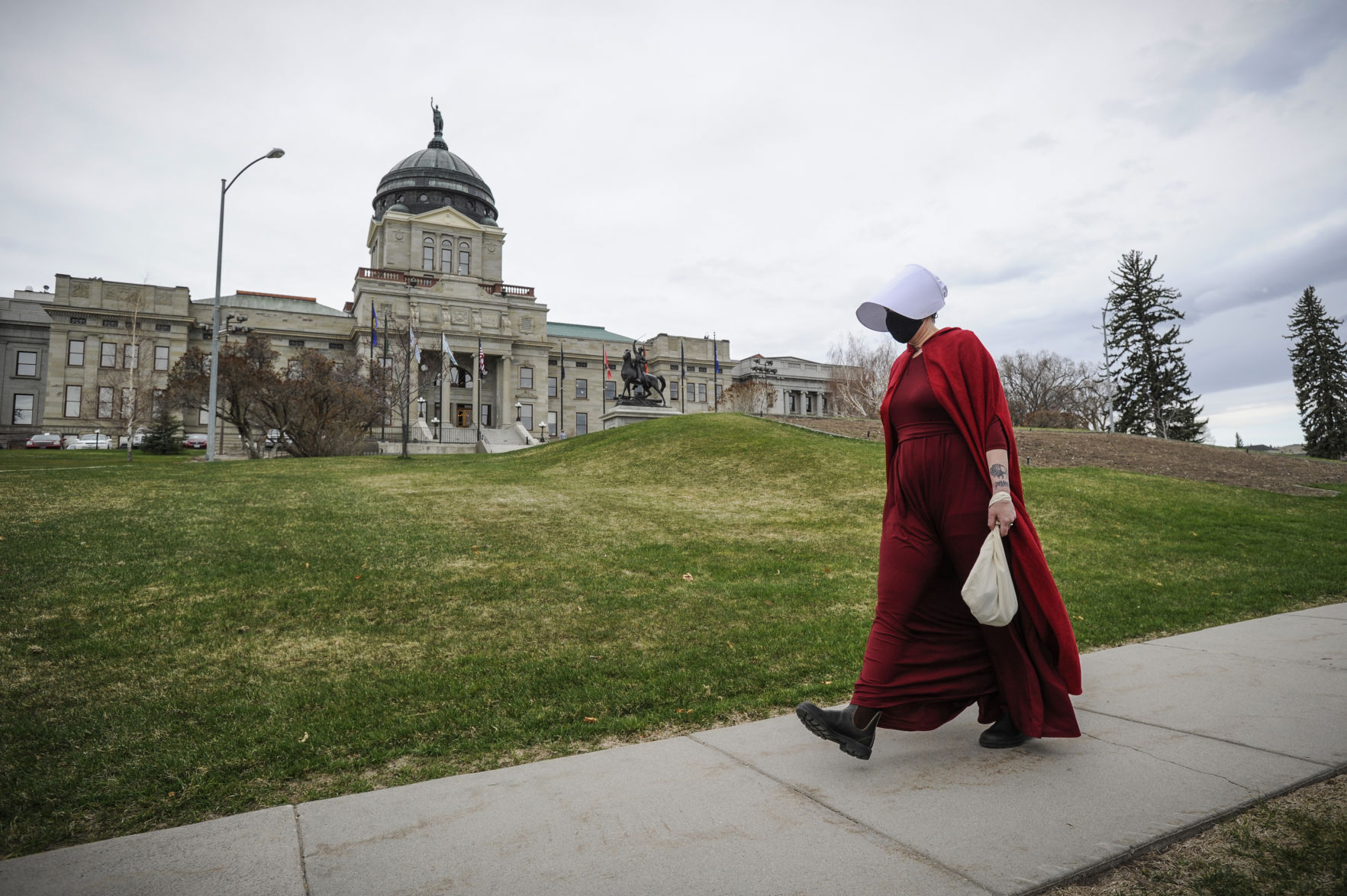 A woman dressed as a handmaid